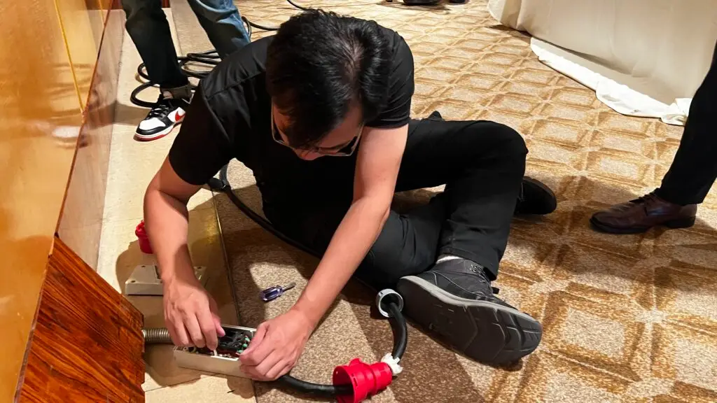 Professional Audio Visual Tech Singapore fixing last minute power issues at event